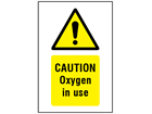 Caution Oxygen in use symbol and text safety sign.