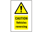 Caution Vehicles reversing symbol and text safety sign.