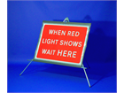 When red light shows wait here roll up road sign