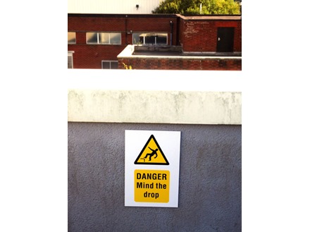 Caution, Mind the drop symbol and text safety sign.