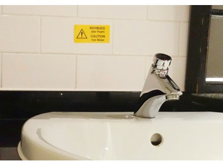 Rhybudd dwr poeth, Caution hot water. Welsh English sign.