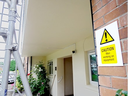 Caution Men working on equipment symbol and text symbol sign.