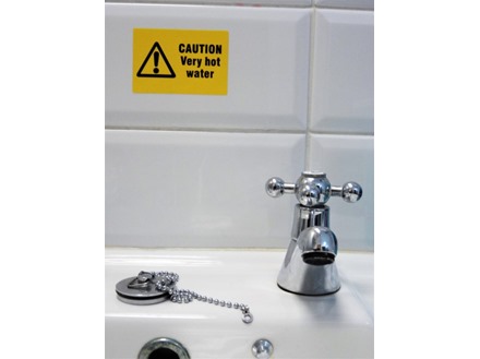 Caution very hot water symbol and text safety sign.