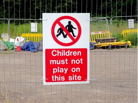 Children must not play on this site symbol and text safety sign.